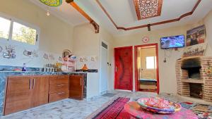 a kitchen with a red door and a fireplace at Adrar N Darn Guesthouse in Taroudant +32 photos