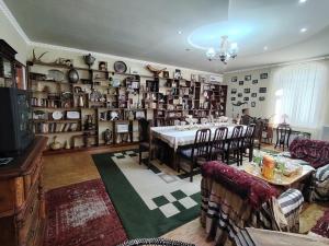 a dining room with a table and a room with shelves at Family Guest House SadNur in Bukhara