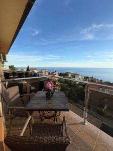 a table and chairs on a balcony with a view of the ocean at Sunset Residence Blizikuce in Budva