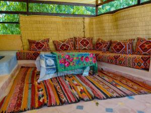 a couch with colorful pillows and a rug at Adrar N Darn Guesthouse in Taroudant