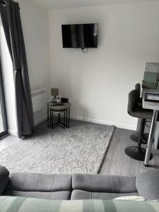 a living room with a couch and a tv on a wall at Hillview Cabin in Oban