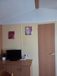 a room with a door and a television on a cabinet at ferme de castel pouzouilh in Le Fossat