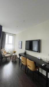 a living room with a table and chairs and a tv at Studio Sapphire Hạ Long View Biển in Ha Long