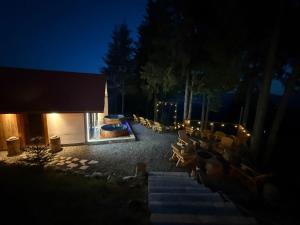 a building with a fire pit and chairs at night at Tiarra Mountain Lodge in Beliş