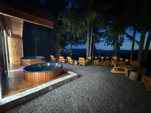 a hot tub on a deck with tables and chairs at Tiarra Mountain Lodge in Beliş