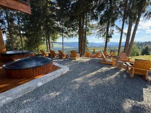 a large hot tub in a yard with chairs and trees at Tiarra Mountain Lodge in Beliş