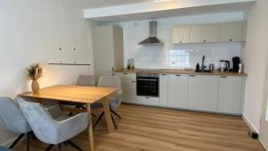 a kitchen with a wooden table and white cabinets at Bergidylle- Saniert und Hochwertig mit Massivholzmöbeln, Sonnenterrasse in der Natur, fußgängig ins Zentrum in Kurort Altenberg
