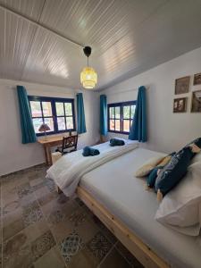 a bedroom with a large bed with blue curtains at Kellaki Village House in Kellaki