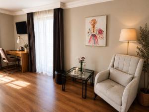 a living room with a chair and a table at Vila Kristina in Negotin