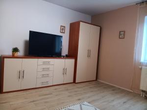 a living room with a flat screen tv on a cabinet at Zum Graureiher in Heringsdorf