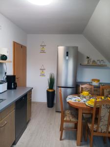 a kitchen with a table and a stainless steel refrigerator at Zum Graureiher in Heringsdorf