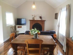 a living room with a table and a fireplace at Robin Hoods Well Farm Stay in Sassafras