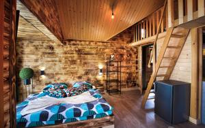 a bedroom with a bed and a wooden wall at Villa Bellevue Wellness in Liptovský Mikuláš