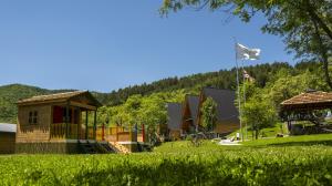 a playground in a park with a house and trees at SaguleResort in Monasteri