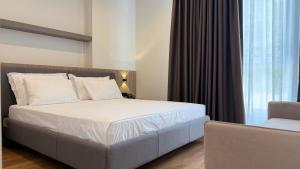 a bedroom with a white bed and a window at Art Hotel Vlora in Vlorë