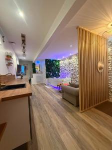 a living room with a couch and a tv at Villa Romance Intime Prestige -Jacuzzi Privatif, , Table a massage , Fauteuil tantra, Balançoire romantique in Vienne