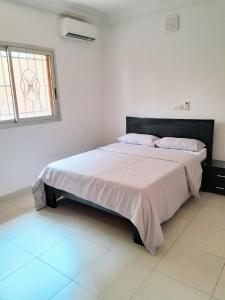 a bedroom with a large bed in a room at Villa Terracotta - Riviera Synacassi - 3 chambres in Abidjan