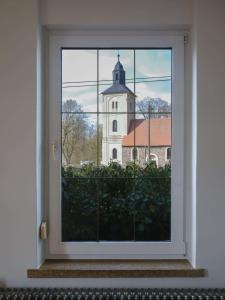 an open window with a view of a church at Das Bauhaus-Eck in Dobritz