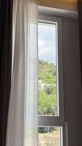 a window with a white curtain in a room at Art Hotel Vlora in Vlorë +56 photos
