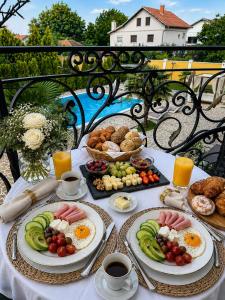 a table with plates of breakfast food on it at Vila Kristina in Negotin