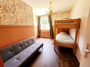 a living room with a couch and a bunk bed at La Pastellière - Combrand in Combrand