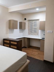 a bedroom with a bed and a desk and a window at Astha lodge in Solan