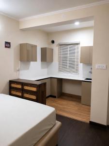 a room with a bed and a kitchen with a window at Astha lodge in Solan