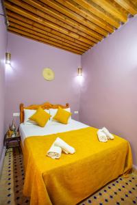 a bedroom with a bed with two towels on it at Riad Mozaik Fes in Fez