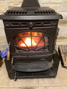 a black stove with a fire inside of it at Butterfly cottage in Belmullet