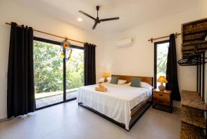 a bedroom with a bed and a large window at Villa Osa Mythica in Puerto Jiménez