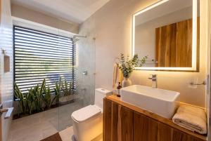 a bathroom with a sink and a toilet and a mirror at Villa Osa Mythica in Puerto Jiménez +5 photos