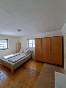a bedroom with a bed and a large wooden cabinet at Gästehaus Hammerle Holzgau in Holzgau