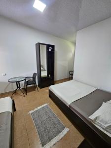 a bedroom with a bed and a table and chairs at Guesthouse Las Palmas in Ureki
