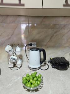 a coffee maker and a bowl of green fruit on a counter at Guesthouse Las Palmas in Ureki
