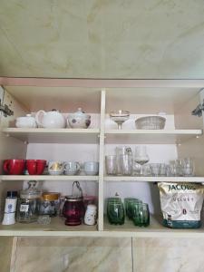 a cupboard filled with lots of dishes and bowls at Guesthouse Las Palmas in Ureki