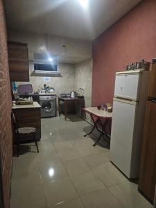 a kitchen with a white refrigerator and a table at Guesthouse Las Palmas in Ureki +16 photos