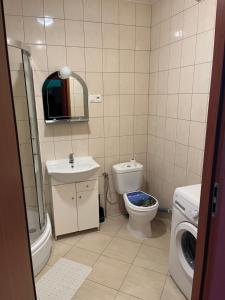 ein Badezimmer mit Toilette, Waschbecken und Waschmaschine in der Unterkunft Arkadiusz in Tarnobrzeg