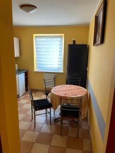eine Küche mit Tisch und Stühlen und einem Fenster in der Unterkunft Arkadiusz in Tarnobrzeg