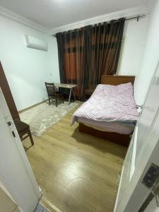 a bedroom with a bed and a table in it at Maqsad 24 in Kafr ash Sharā‘inah