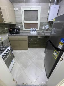 a small kitchen with a sink and a refrigerator at Maqsad 24 in Kafr ash Sharā‘inah