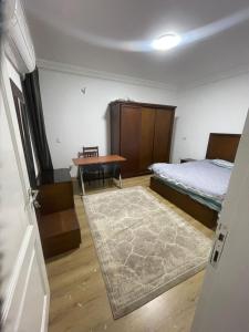 a bedroom with a bed and a desk and a table at Maqsad 24 in Kafr ash Sharā‘inah