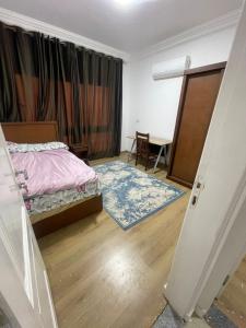 a bedroom with a bed and a table and a door at Maqsad 24 in Kafr ash Sharā‘inah