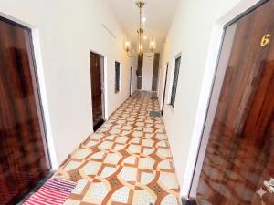 a hallway with a tile floor and a chandelier at Hotel bhagwati palace in Orchha