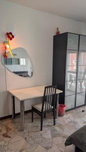 a table and a chair in a room with a mirror at ANDREA - Chiassi in Brescia +30 photos