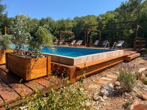 a swimming pool in a yard with chairs around it at Wilgano in Rvaši