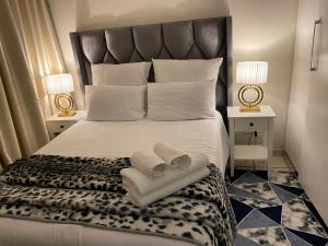 ein Schlafzimmer mit einem großen Bett, auf dem Handtücher liegen in der Unterkunft Comfy Nest Guest House in Durban