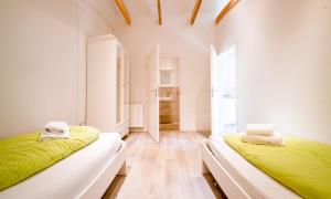 two beds in a white room with green sheets at Ottos Ferienhäuser in Rabenkirchen-Faulück