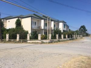 an empty street in front of a white house at Wild Caspian coast in Aşağıoba