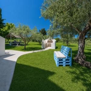 a blue bench sitting on the grass in a park at Sa lampana in Orosei