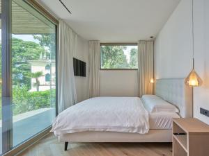 a bedroom with a bed and a large window at Apartment La Baia in Torri del Benaco +17 photos